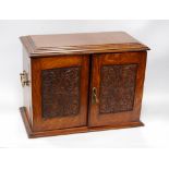 Late Victorian oak smoker's cabinet with carved panelled doors enclosing a fitted interior,