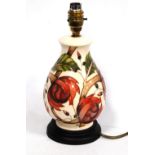 Moorcroft table lamp with rose and bud pattern on a cream ground, 29cm high.