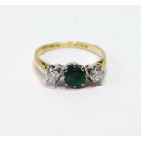 Three-stone ring with circular emerald and diamond brilliants in 18ct gold, 1977, size K½.