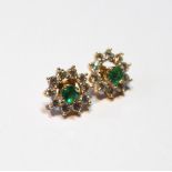 Pair of cubic zirconia and emerald circular earrings.