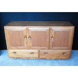 Ercol Golden Dawn sideboard fitted with three drawers flanked by cupboards,