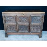 19th century oak coffer, the rectangular top over carved panels flanked by doors,