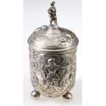 German silver embossed cup and cover with figure scenes and scrolls upon matting,