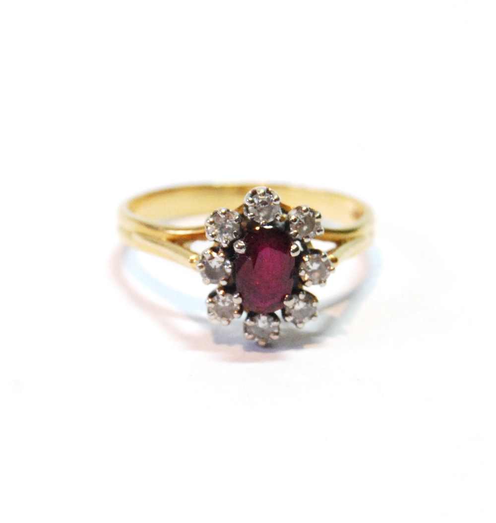 Diamond and ruby oval cluster ring in 18ct gold, 1977, size M.