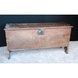 Large oak coffer of rectangular form, the hinged top raised on shaped feet.