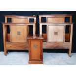 Pair of mahogany single beds, each with projected moulded top over central oak leaf panel,