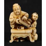 Japanese carved ivory okimono depicting a street seller at a table counting on an abacus,