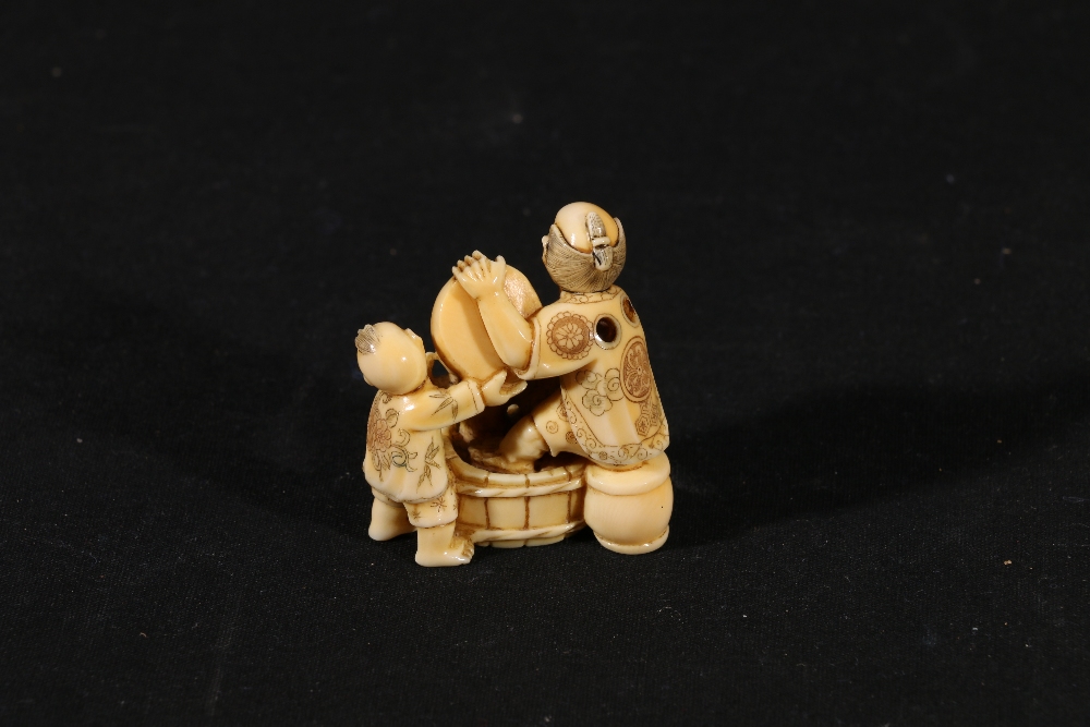 Japanese carved ivory okimono with netsuke himatoshi depicting a man and a boy pouring water into a - Image 3 of 3