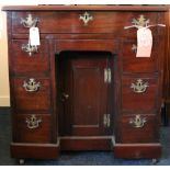 19th century mahogany and crossbanded kneehole desk or dressing table raised on castors,