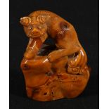 Small Chinese carving of a Kylin seated on a rock, possibly amber,