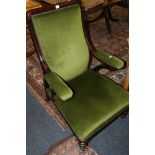 Victorian mahogany open armchair raised on carved feet and brass castors, upholstered in green.