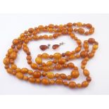 Amber bead necklace and a pair of similar earrings. Condition Report.