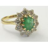 Diamond and emerald oval cluster ring with ten brilliants in gold, size 'R ½'.