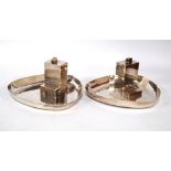 Pair of silver ashtrays of rounded triangular shape, each with a model of an office block,