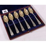 Set of six silver berry spoons of double struck feather pattern with gilded bowls.