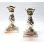 Pair of silver boudoir candlesticks with dumpy spirally fluted Corinthian columns on similar square