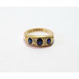 Sapphire and diamond three-stone ring with four small brilliants, 18ct gold, 1924, size N, 3g.