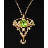 Edwardian gold brooch/pendant of Art Nouveau form with peridot of good colour amid sprays of pearls,