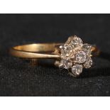 18ct gold seven stone diamond ring arranged in a flowerhead pattern, size P, 2.3g.