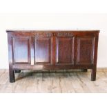 18th Century oak coffer, the four panel front carved I.B, 1720, on style supports, 142cm wide.