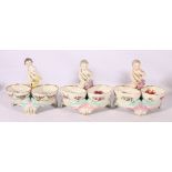 Pair of continental porcelain sweetmeat dishes in the form of a cherib with twin dishes on