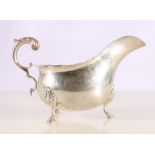 Sterling silver cream boat with scroll handle raised on three supports, stamped to base "Sterling",