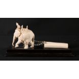 Early 20th Century Indian carved ivory model of an elephant pulling a log with chains, wooden stand,