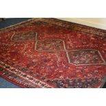 Eastern red ground carpet with triple medallion centre framed by multiple guards,