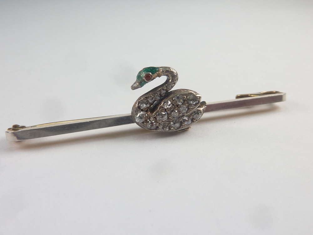 Pin with diamond and enamel swan in gold, platinum fronted. C1900. Condition Report.