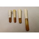 Four late 19th century Meerschaum cigar and cheroot holders, all with amber stems,