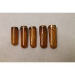 Five late 19th century short amber cheroot holders with metal mounts each approximately 3cm - 3.5cm.