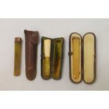 Two simulated amber cigar holders with metal mounts and another with Meerschaum top, all cased,