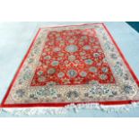 Large Chinese floral wool carpet with red ground.