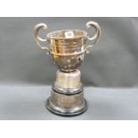 Silver two handled cup, with plinth. Condition Report.