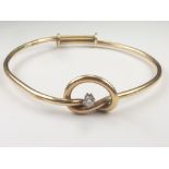 Gold plain bangle with diamond set knot, probably 9ct. Condition Report. Weight 15g.