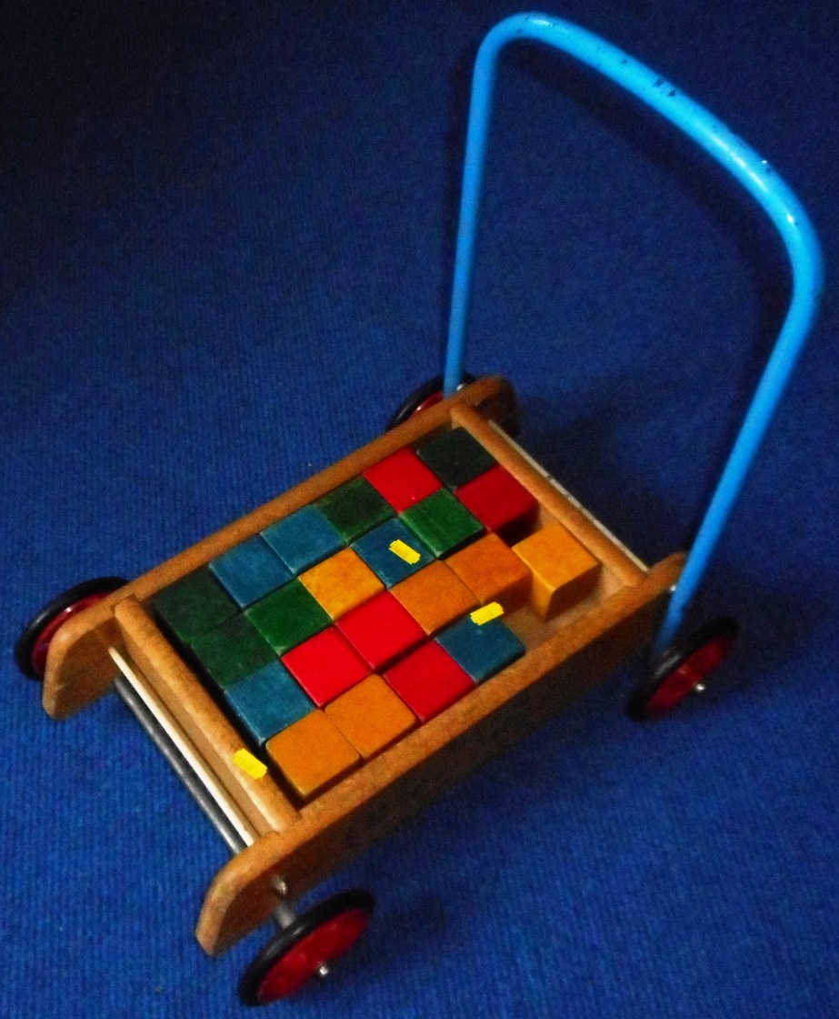 Set of child's wooden building blocks and trolley.