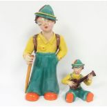 Two early 20th century Hungarian Secessionist pottery figures of a hiker and boy playing a mandolin,