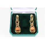 Pair of 18ct gold drop earrings of twisted knot form set with catseye, 14g.