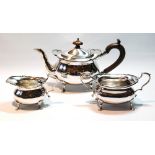 Silver individual three-piece tea set of ovoid boat shape with waved edges on paw feet,