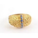 Gold ring with a band of tiny sapphires upon basket work. Size 'P 1/2'. Condition Report.