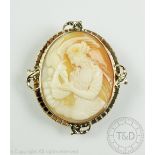 A carved shell cameo brooch, the oval cameo depicting Hebe and the egale,