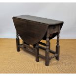 An 18th century and later oak gate leg table, with replaced drawer, on turned and block legs,