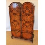 A Queen Ann style walnut double dome top wardrobe, on stand with cabriole legs,