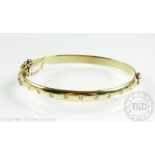 A 9ct yellow gold and diamond set hinged bangle, London 2000,