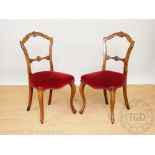 A set of four Victorian carved walnut dining chairs, with upholstered seats, on cabriole legs,