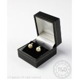 A pair of pearl and emerald set stud earrings, designed as an emerald stud,