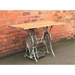 A cast iron and wood garden table, converted from a treadle sewing machine, 75cm H x 115cm W x 57.