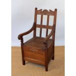 A George V pine commode chair dated '1917', with hinged seat,