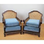 A pair of Edwardian carved walnut bergere chairs, with double caning,