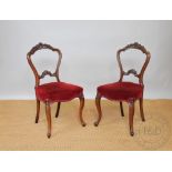 A set of four Victorian carved walnut dining chairs, with upholstered seats, on cabriole legs,